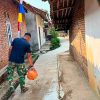 Rawat Hasil Pembangunan, Satgas TMMD Ke-129 Siram Jalan Beton Demi Kualitas Maksimal